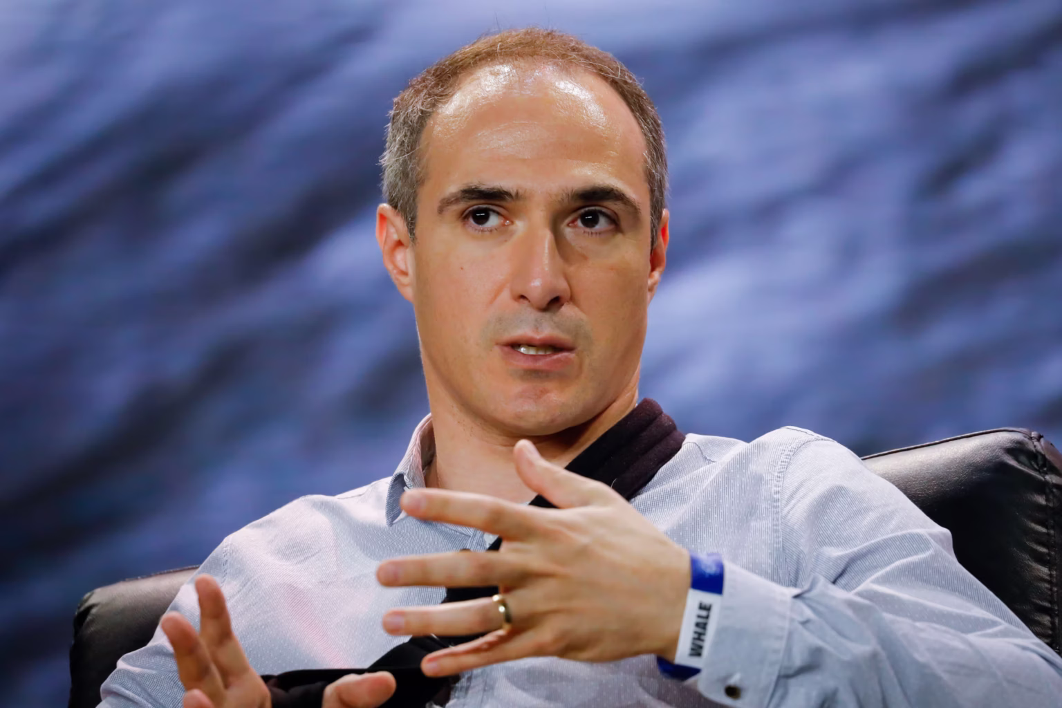 A professional photo of **Michael Shaulov**, co-founder and CEO of **Fireblocks**, speaking into a red microphone with the word "TECH" on it. He is a man with a receding hairline, wearing a white collared shirt.